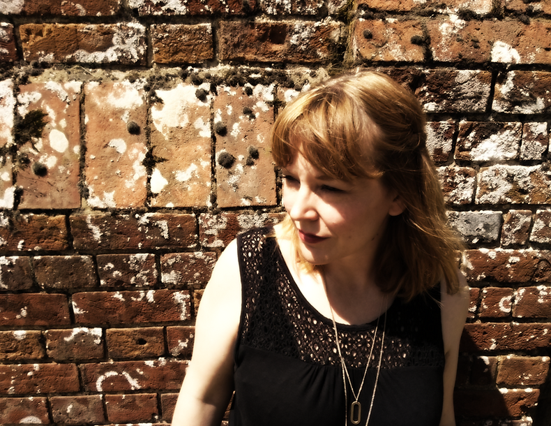 Emily Grice photographed against a brick wall